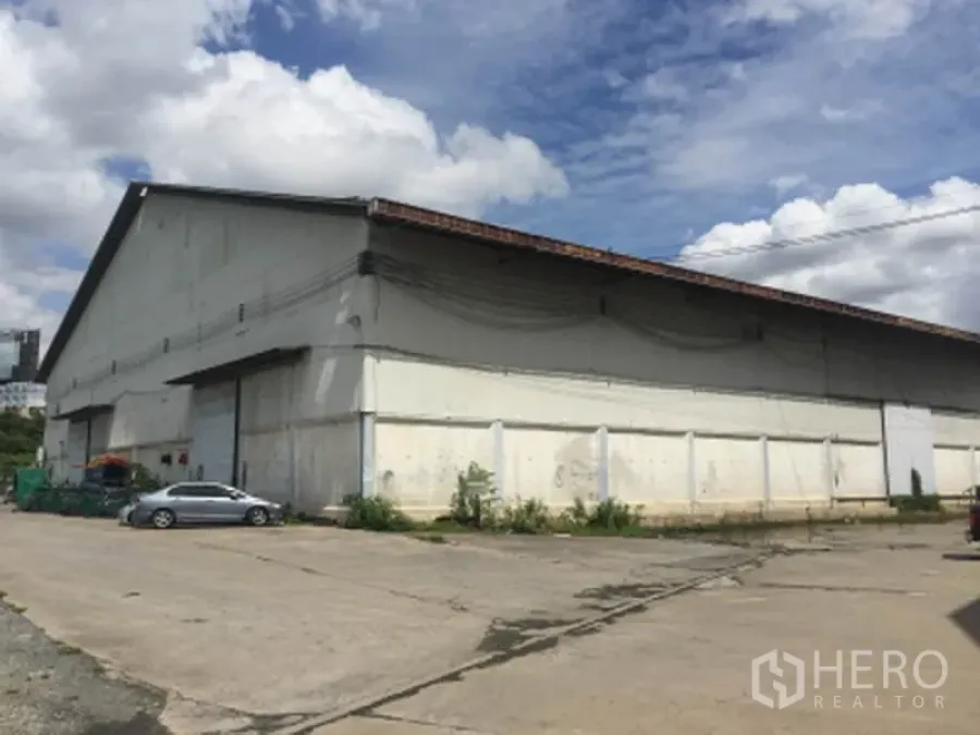 คลังสินค้า ให้เช่าในPak Kret, Nonthaburi - ด้านหน้าอาคารโกดังขนาดใหญ่ มีลานจอดและถนนทางเข้าออกกว้าง