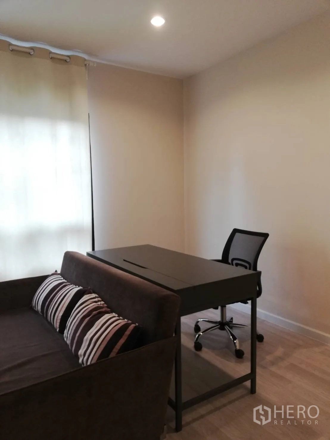 Townhouse for rent in Bang Kapi, Bangkok - Flexible room staged as a home office with sofa, study desk and mesh chair.