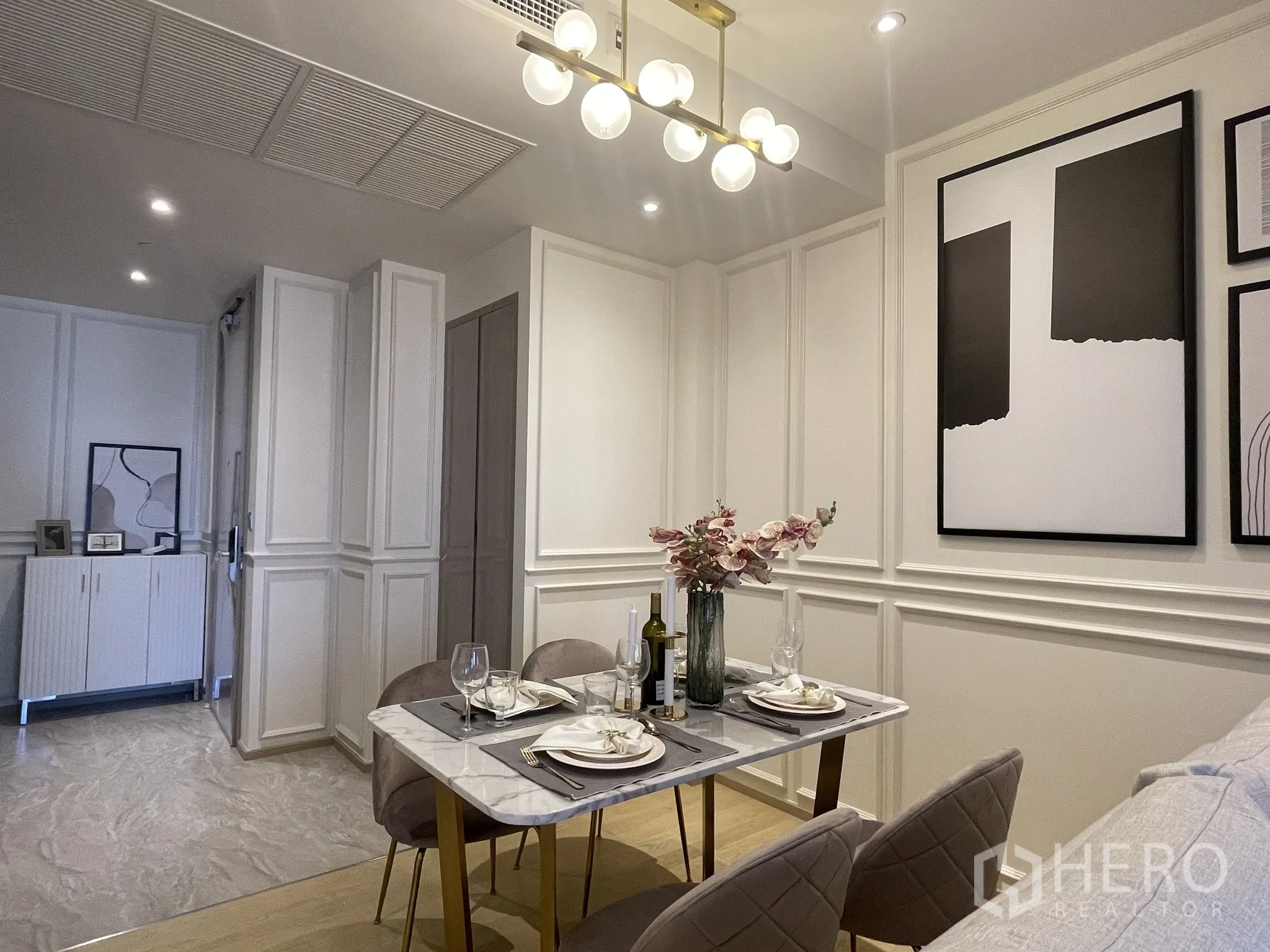 คอนโด ให้เช่าในDin Daeng, Bangkok - มุมใกล้โต๊ะอาหารท็อปหินอ่อน เก้าอี้กำมะหยี่ แจกันดอกไม้ และโคมไฟแขวนโทนทอง