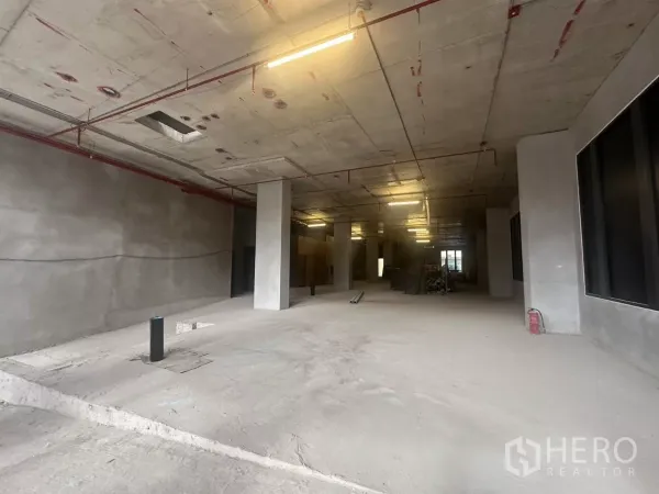 零售空间 出租在Watthana, Bangkok - 室内深进的零售区，可见立柱、外露天花与喷淋管线。