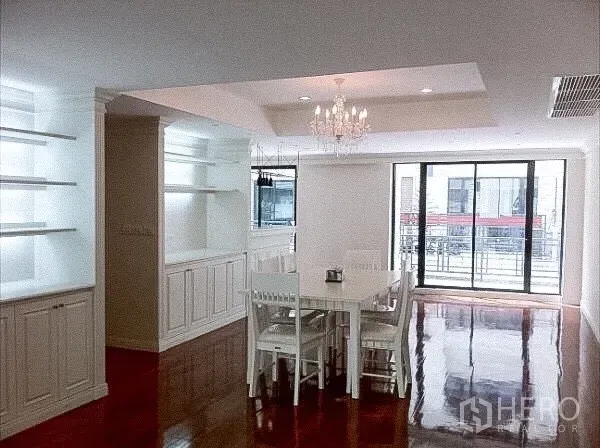 联排别墅 出租在Khlong Toei, Bangkok - 明亮餐厅，水晶吊灯、内置柜、亮面木地板与落地移门阳台。