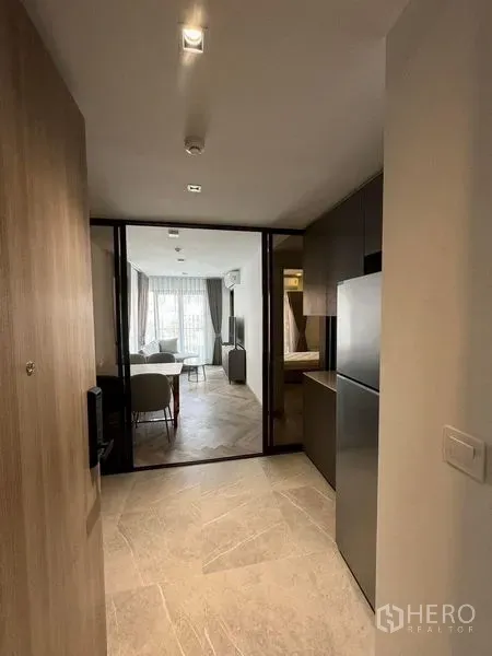 Condominium for rent in Watthana, Bangkok - Entry hallway with kitchenette and glass partition leading to a bright living area in a modern Bangkok condo.