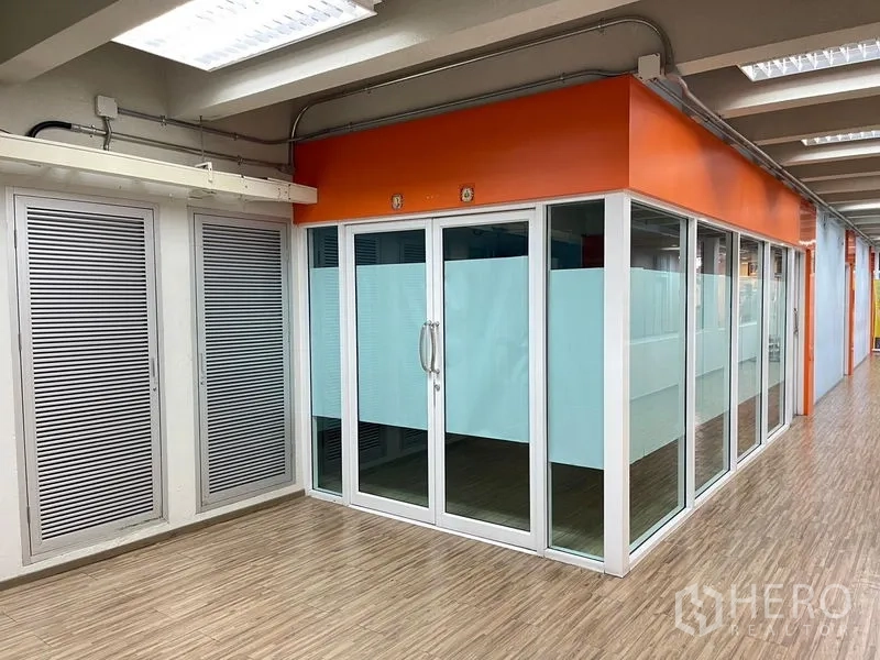 สำนักงาน ให้เช่าในRatchathewi, Bangkok - ด้านหน้าห้องสำนักงานผนังกระจก ติดฟิล์มฝ้าและประตูกระจกคู่ ใกล้พื้นลายไม้ทางเดิน.