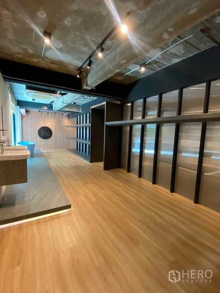 带办公室的家 出租在Wang Thonglang, Bangkok - 开阔办公区，木地板与长排置物架、抬高平台和工业风顶