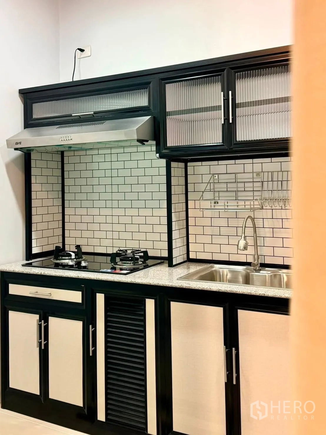 Townhouse for rent in Bang Phli, Samut Prakan - Modern kitchen with gas hob, stainless hood, subway-tile backsplash, and sink.