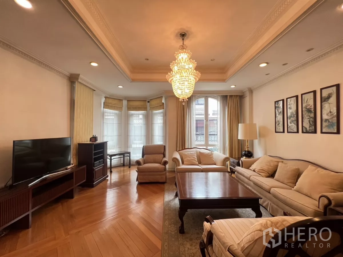 ทาวน์เฮาส์ ขายในWatthana, Bangkok - ห้องนั่งเล่นสว่าง โคมแชนเดอเลียร์ หน้าต่างเบย์ โซฟาสีครีม และพื้นไม้