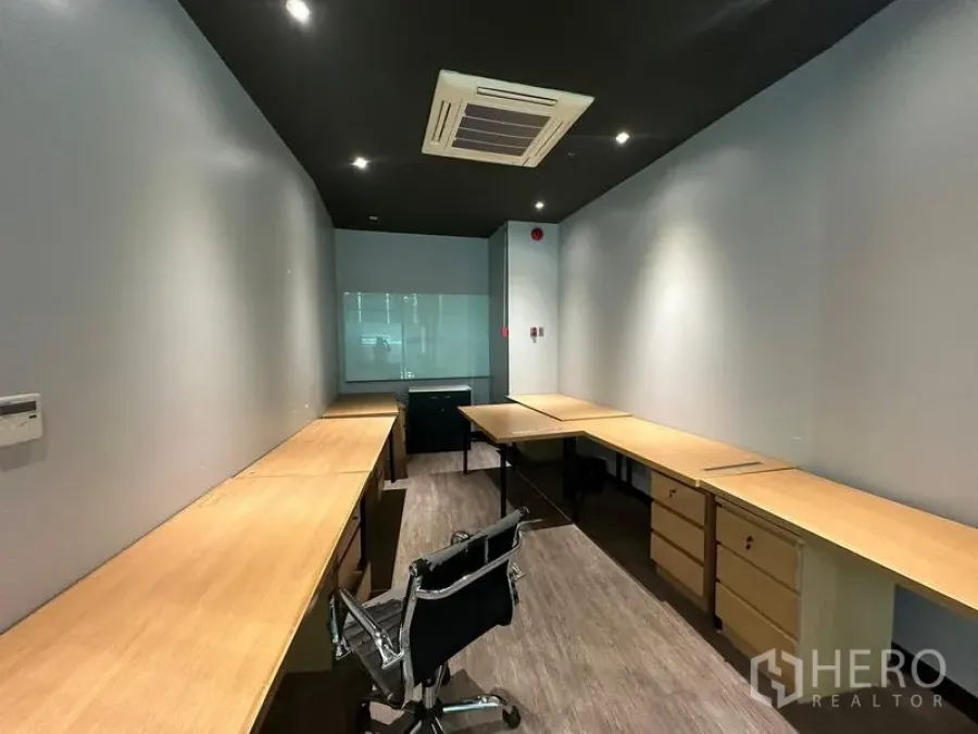 Office Space for rent - Narrow furnished office room featuring twin workstations, drawers, recessed lighting and cassette air conditioner.