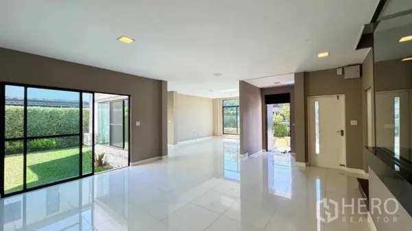 บ้าน ขายในBang Kapi, Bangkok - พื้นที่นั่งเล่นและทานอาหารแบบโอเพน แสงธรรมชาติ พื้นกระเบื้องขาว มองเห็นสนามหญ้า