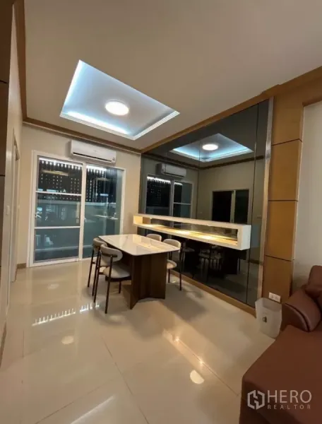 Townhouse for rent in Wang Thonglang, Bangkok - Dining area with marble table, mirror feature wall and cove ceiling lights
