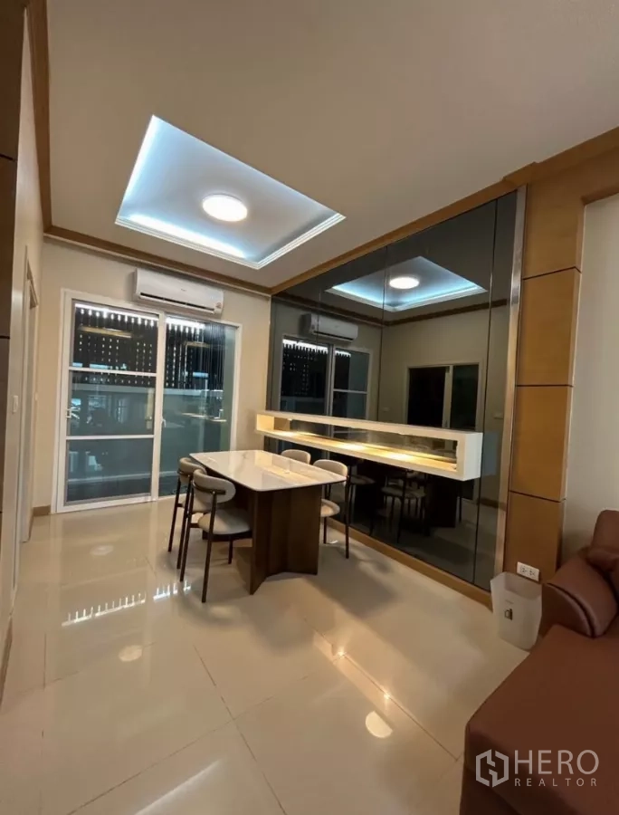 Townhouse for rent in Wang Thonglang, Bangkok - Dining area with marble table, mirror feature wall and cove ceiling lights