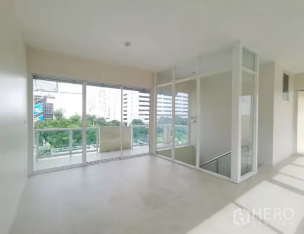 独立商业地产 出售在Bang Rak, Bangkok - 转角房间配落地玻璃与推拉门阳台，可见城市与绿意景观。