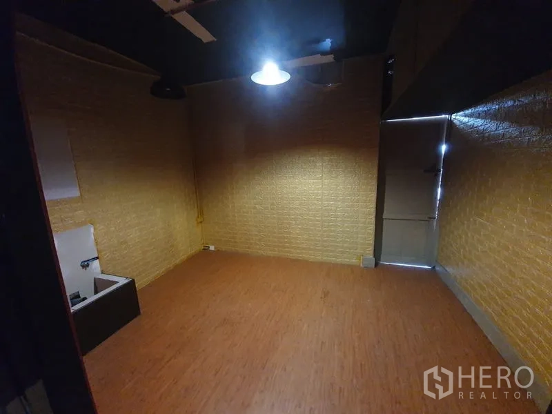 อาคารพาณิชย์ ให้เช่าในKhlong Toei, Bangkok - ห้องภายในขนาดกะทัดรัด ผนังลายอิฐ พื้นลายไม้และไฟแขวนดวงเดียว