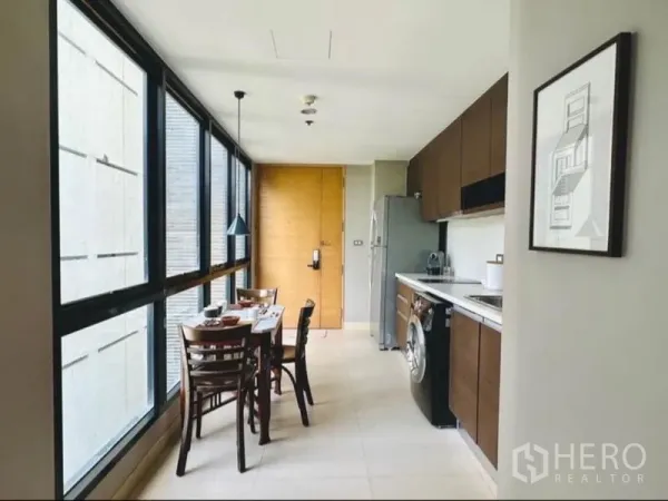 Condominium for rent in Watthana, Bangkok - Bright kitchen and dining nook lined with floor‑to‑ceiling windows.