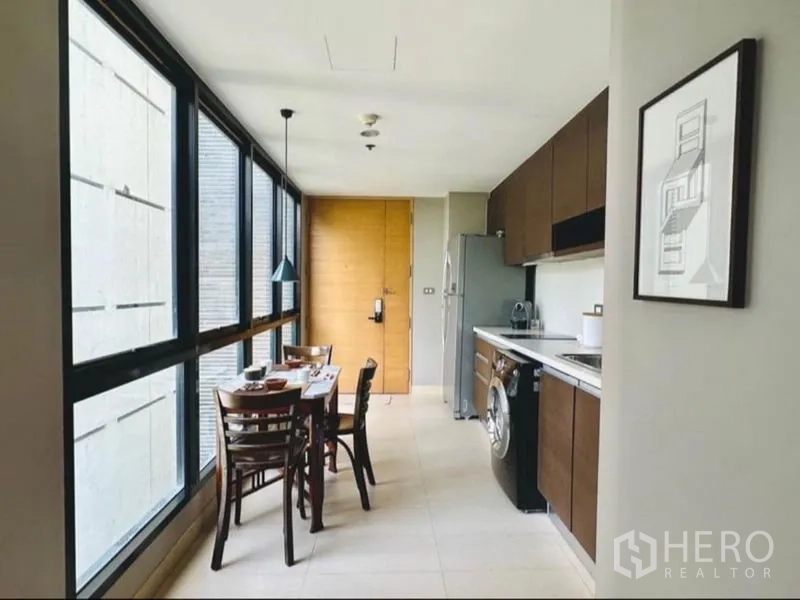 Condominium for rent in Watthana, Bangkok - Bright kitchen and dining nook lined with floor‑to‑ceiling windows.