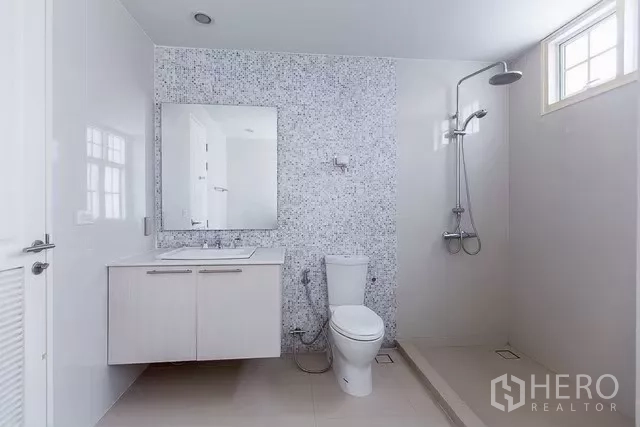 Townhouse for rent in Watthana, Bangkok - Rooftop terrace with city views and wall lights for evening use.