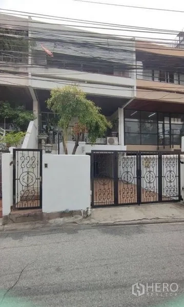 Home Office for rent in Watthana, Bangkok - Street view of gated townhouse-style home office facade.