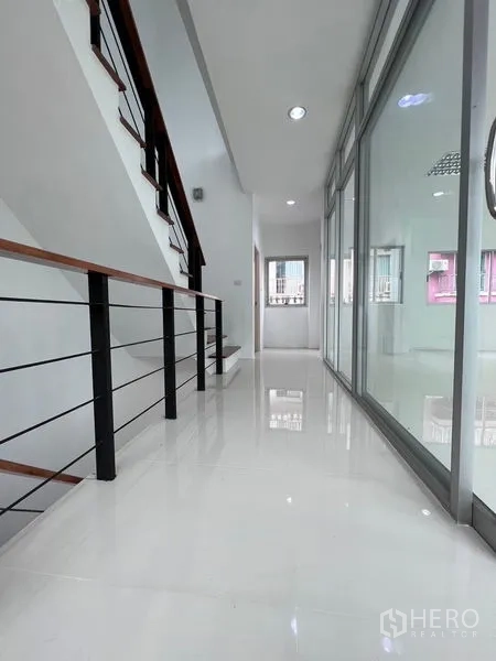 Home Office for sale in Lat Krabang, Bangkok - Bright corridor with glossy white tiles and glass-partitioned office rooms.