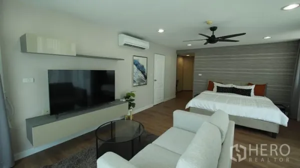 คอนโด ให้เช่าในKhlong San, Bangkok - ห้องนอนมาสเตอร์กว้าง เตียงคิง โซฟานั่งเล่น ทีวีติดผนัง และพัดลมเพดาน