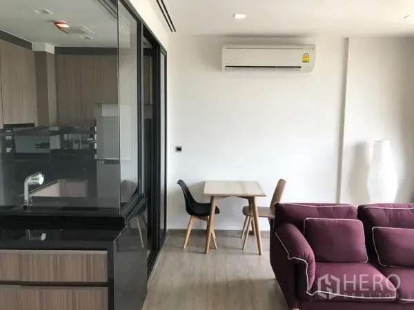 คอนโด ให้เช่าในWatthana, Bangkok - มุมรับประทานอาหารกะทัดรัดข้างครัวกระจก พร้อมโซฟาและเครื่องปรับอากาศติดผนัง