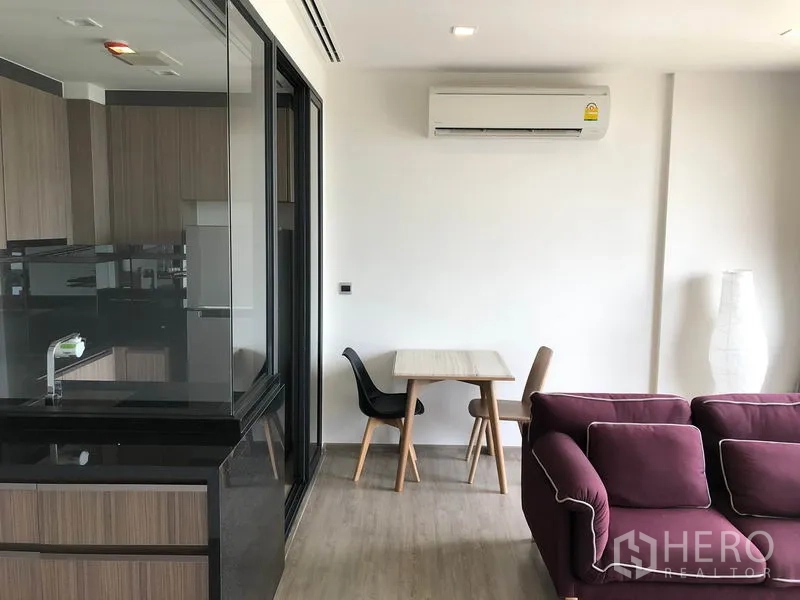 คอนโด ให้เช่าในWatthana, Bangkok - มุมรับประทานอาหารกะทัดรัดข้างครัวกระจก พร้อมโซฟาและเครื่องปรับอากาศติดผนัง