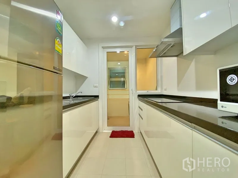 คอนโด ให้เช่าในKhlong Toei, Bangkok - ครัวปิดสไตล์แกลเลอรี ตู้สีขาว ท็อปสีดำ และตู้เย็นสเตนเลส