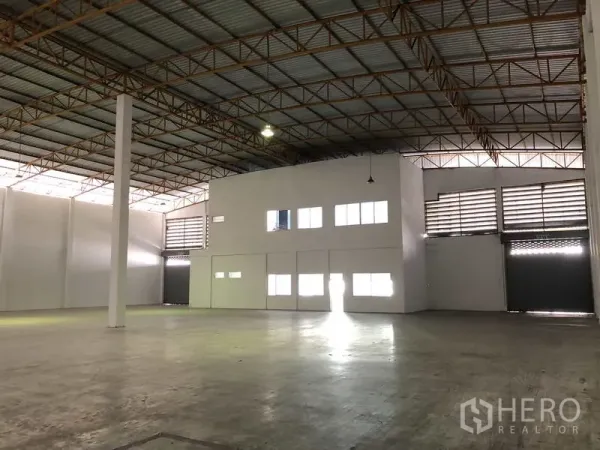 货栈 出租在Phra Nakhon Si Ayutthaya - 仓库大厅带内部办公盒体、卷闸装卸门与大面积净空地面。