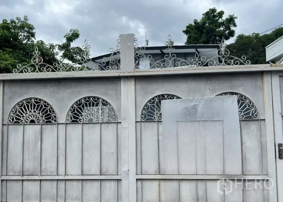 บ้าน ให้เช่าในPhra Khanong, Bangkok - สันหลังคาบ้านสองชั้นโผล่เหนือรั้วตกแต่งลายเหล็กดัด พร้อมพื้นที่สีเขียว