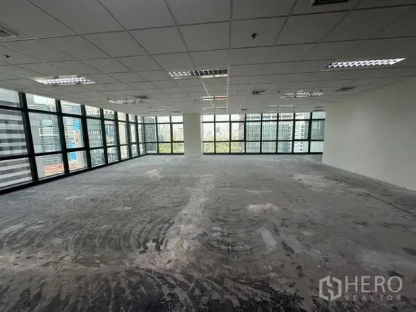 办公空间 出租在Bang Rak, Bangkok - 宽敞未配家具的办公楼层，大窗与中央立柱，眺望曼谷天际线。