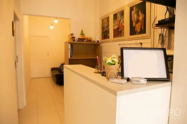 店屋 出租在Khlong Toei, Bangkok - 接待区，白色前台、置物架与装饰画。