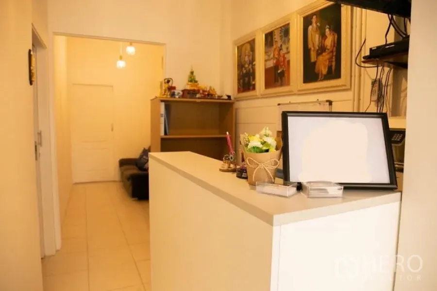 อาคารพาณิชย์ ให้เช่าในKhlong Toei, Bangkok - เคาน์เตอร์ต้อนรับสีขาว พร้อมชั้นวางของและภาพแขวนผนัง