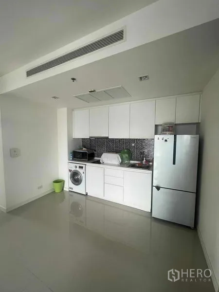 Condominium for sale - Compact built-in white kitchen with refrigerator, washer and backsplash.
