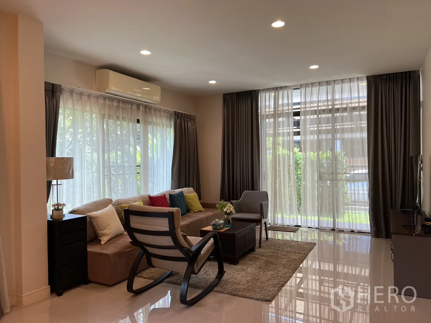 บ้าน ให้เช่าในBang Kapi, Bangkok - ห้องนั่งเล่นสว่างด้วยโซฟา ผ้าม่านโปร่ง และไฟดาวน์ไลท์