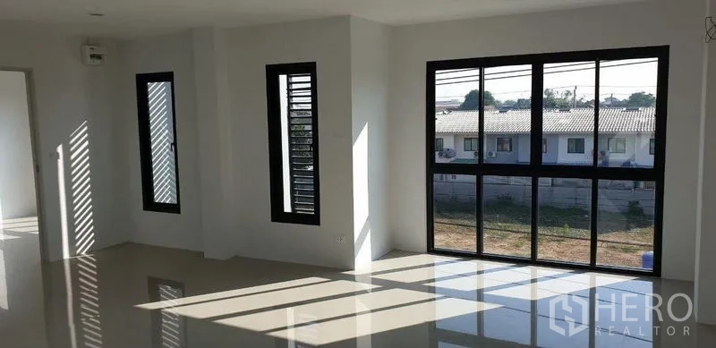 Factory for rent in Lam Luk Ka, Pathum Thani - Front elevation of a twin-bay factory complex with secure driveway gate.