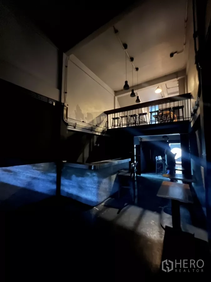 店屋 出租在Watthana, Bangkok - 面向夹层与工业风吊灯的开放式空间视角。