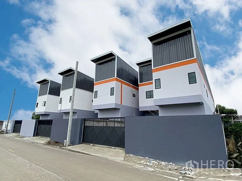 工厂 出租在Bang Bua Thong, Nonthaburi - 多栋新建工厂排屋，沿着铺装道路分布并设有大门围墙。