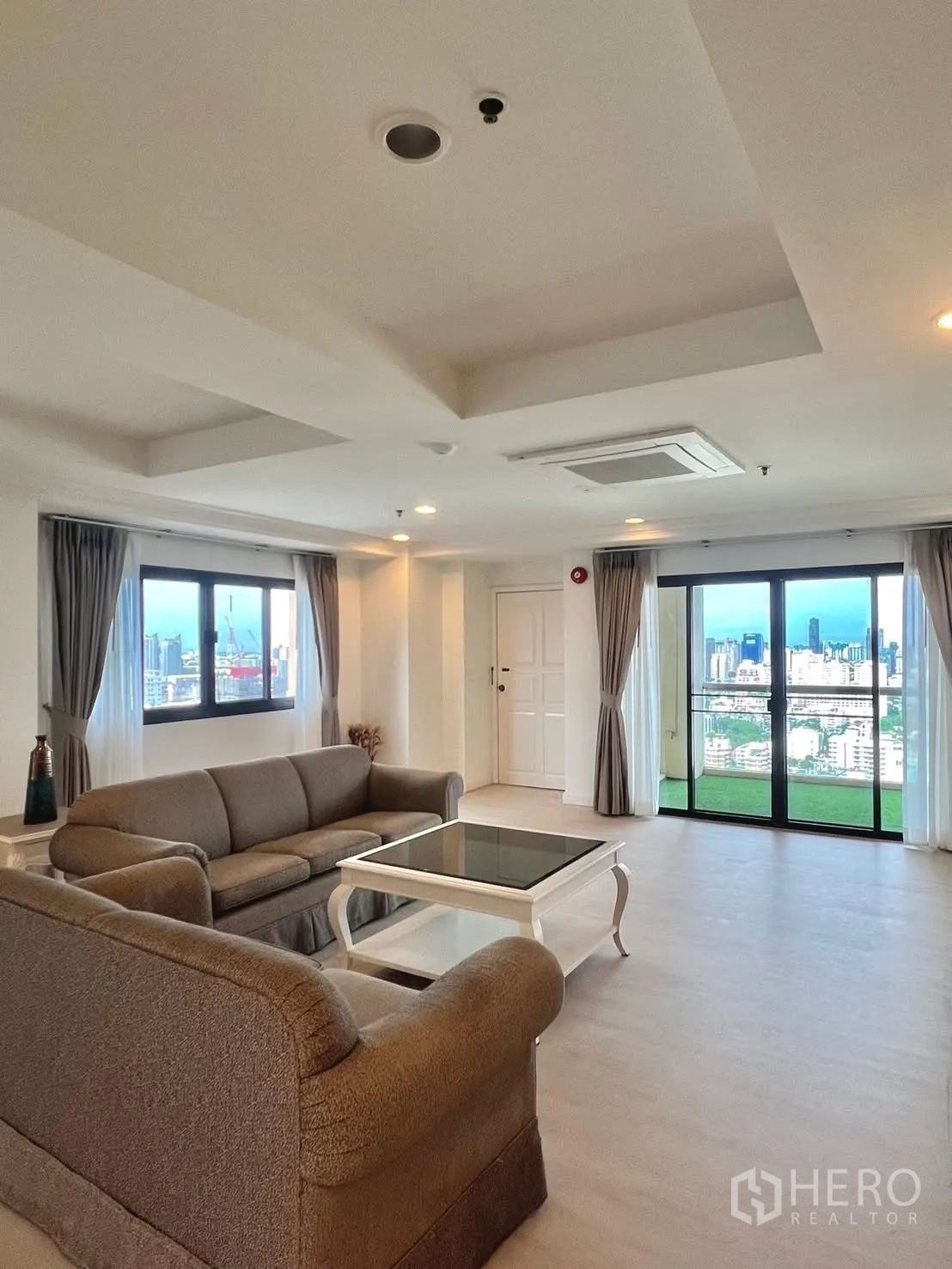 Condominium for rent in Khlong Toei, Bangkok - Living room with sofas, coffee table and balcony city view.