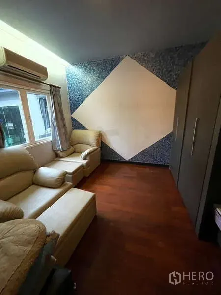 Detached House for sale in Suan Luang, Bangkok - Cozy sitting room with beige sofas, a geometric feature wall and wardrobe.