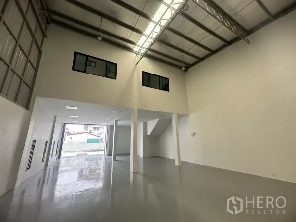 货栈 出售在Khlong Luang, Pathum Thani - 仓库后段，双层通高钢结构屋顶、夹层窗与大卷门。