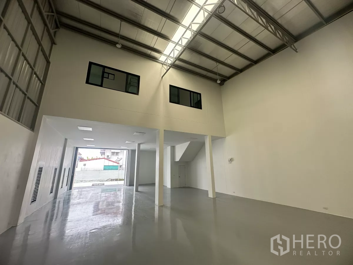 货栈 出售在Khlong Luang, Pathum Thani - 仓库后段，双层通高钢结构屋顶、夹层窗与大卷门。