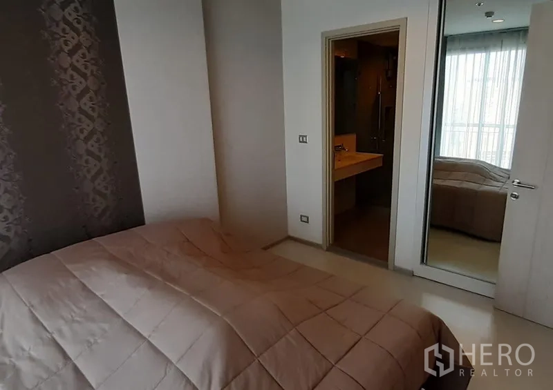 คอนโด ให้เช่าในKhlong Toei, Bangkok - ห้องนอนอบอุ่น ผนังไฮไลต์ ตู้เสื้อผ้าบานกระจก และทางเข้าห้องน้ำ