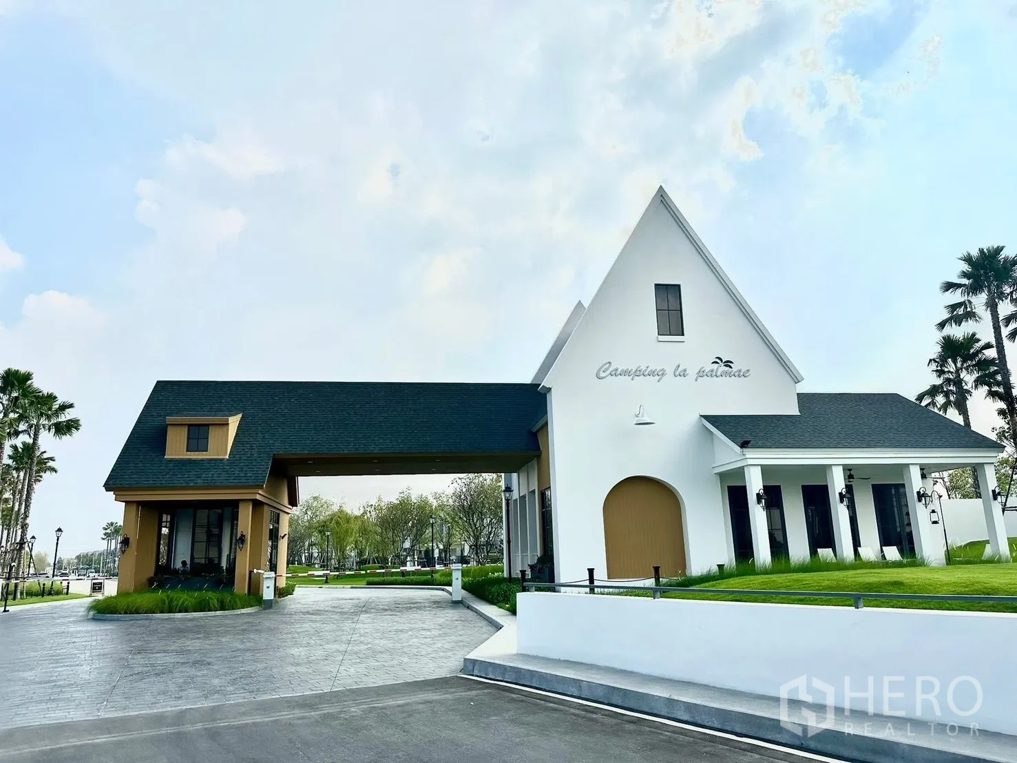 Detached House for rent in Bang Phli, Samut Prakan - Gated development entrance with pitched-roof buildings and landscaped lawn.