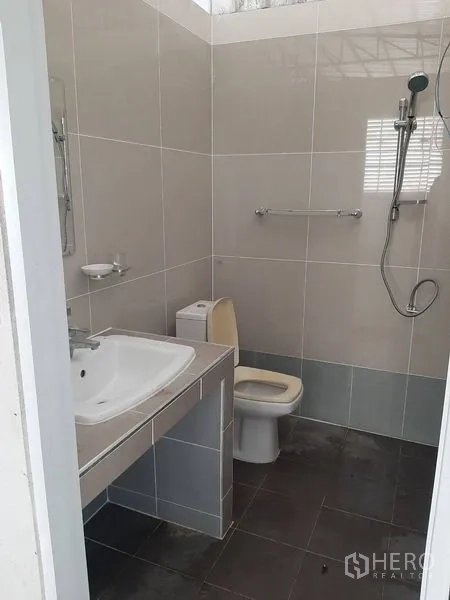 工厂 出租在Lam Luk Ka, Pathum Thani - 整洁的瓷砖卫生间，配洗手台、坐便器与淋浴。