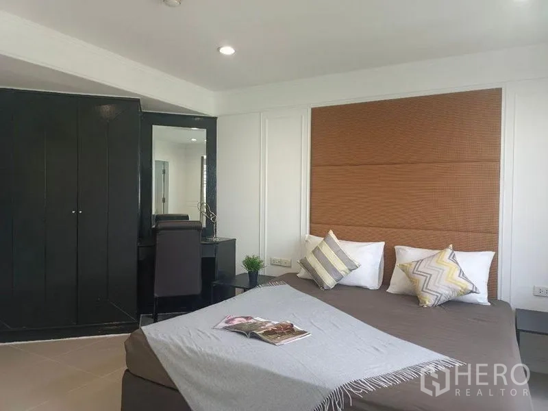 คอนโด ให้เช่าในWatthana, Bangkok - ห้องนอนสำหรับแขก ผนังหัวเตียงแบบมีเท็กซ์เจอร์ โต๊ะทำงาน และตู้สีเข้ม