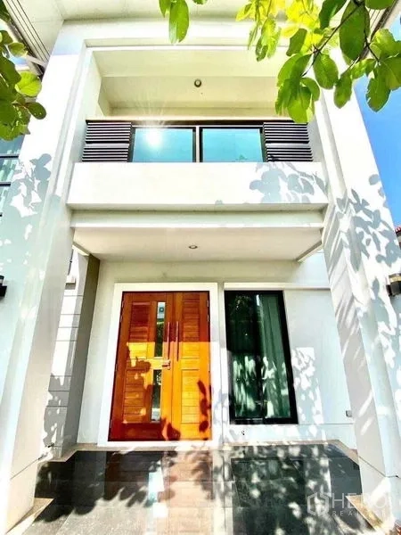 Detached House for sale in Saphan Sung, Bangkok - Front facade of modern two‑storey house with balcony and double wooden entrance door.