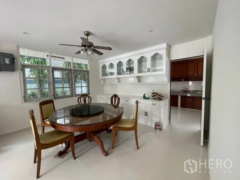 บ้าน ให้เช่าในKhlong Toei, Bangkok - ห้องรับประทานอาหาร โต๊ะกลม เก้าอี้สี่ตัว พัดลมเพดาน และตู้โชว์สีขาว เชื่อมครัว