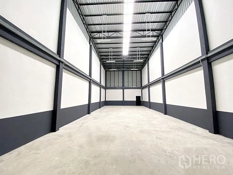 工厂 出租在Bang Bua Thong, Nonthaburi - 厂房内部层高挑，高强度钢梁、LED照明与混凝土地面。