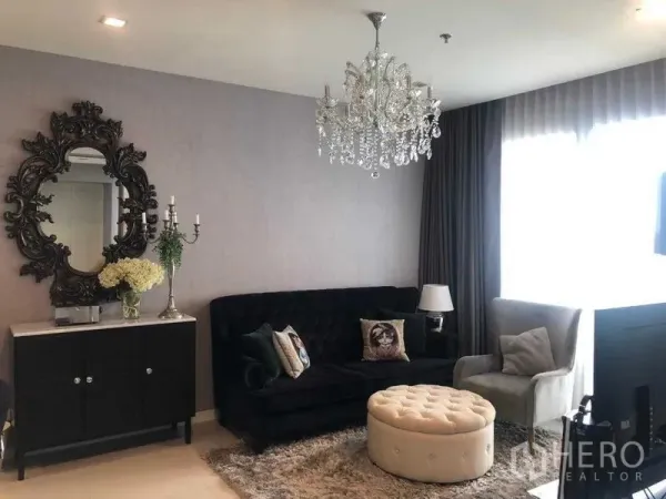 公寓 出租或出售在Bang Kho Laem, Bangkok - 优雅客厅，水晶吊灯、天鹅绒沙发与脚凳，配大面积落地窗帘窗。