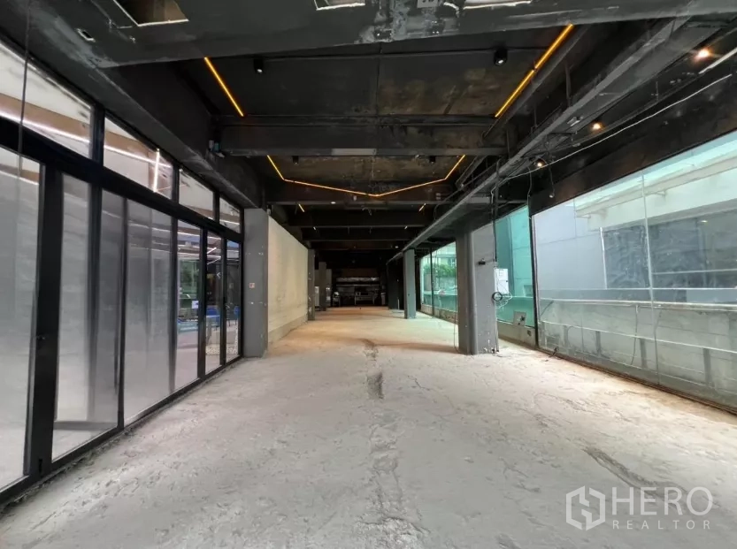 พื้นที่ขายปลีก ให้เช่า - ภายในพื้นที่เปิดโล่ง เพดานสีดำโชว์โครงและไฟเส้น LED พื้นคอนกรีต พร้อมหน้าต่างกระจกบานใหญ่ด้านข้าง