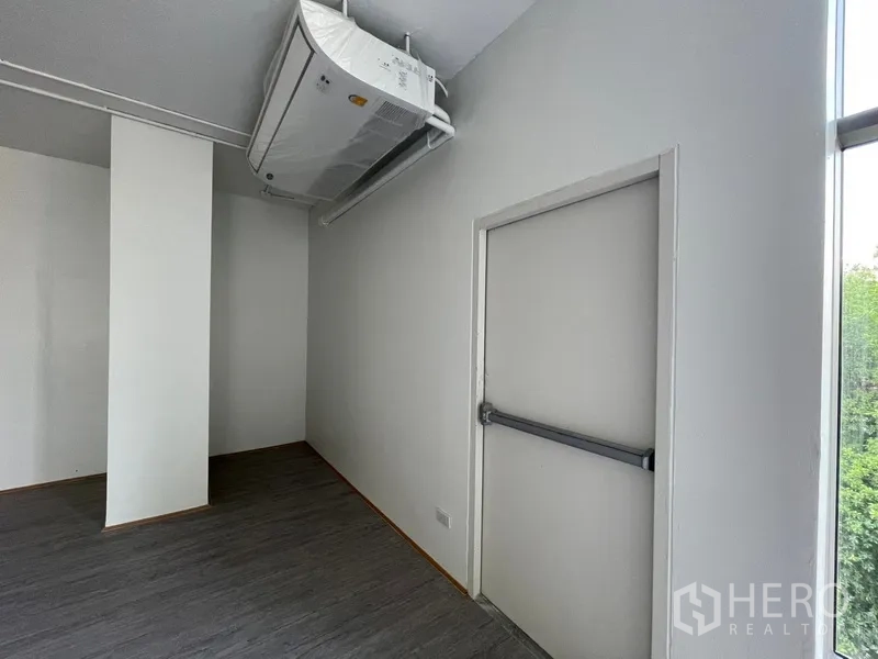 Office Space for rent in Bang Rak, Bangkok - Emergency exit door with crash bar positioned beneath an air-conditioning unit.