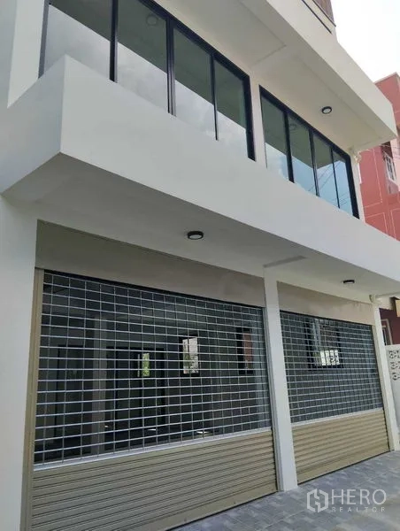 Home Office for sale - Street-level view featuring two roller shutters and large storefront windows suitable for parking or loading.